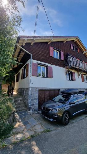 une voiture noire garée devant une maison dans l'établissement Au pied du col, à Luttenbach-près-Munster