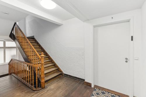 a staircase in a room with white walls and wooden floors at Residenz im historischen Zentrum - Aalen Apartments & Suites in Aalen