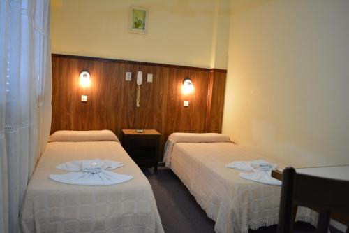 a hotel room with two beds with white sheets at Gran Hotel Amelia in Mar del Plata