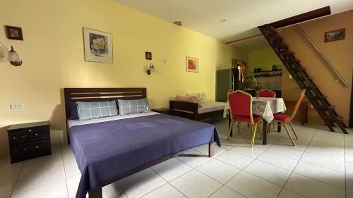 a bedroom with a bed and a table and chairs at Haus am Strand auf Sibuyan Island nahe Cresta de Gallo - Marevic's Guesthouse 1 ohne Klimaanlage in Azagra