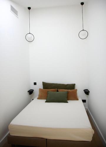 - un lit dans une chambre avec deux lumières au-dessus dans l'établissement Charmant 3P avec terrasse dans la vieille ville, à Antibes