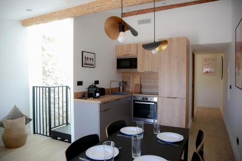 une cuisine avec une table et des chaises ainsi qu'une cuisine avec une table dans l'établissement Charmant 3P avec terrasse dans la vieille ville, à Antibes