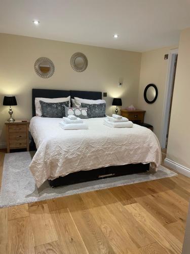 a bedroom with a large bed and wooden floors at Rivington Barn in Kerne Bridge