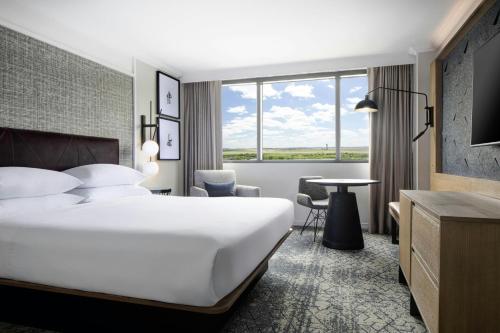 a hotel room with a large bed and a table at Sheraton DFW Airport Hotel in Irving