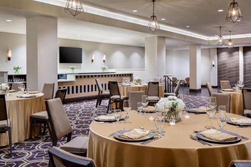 a conference room with tables and chairs and a flat screen tv at Sheraton DFW Airport Hotel in Irving