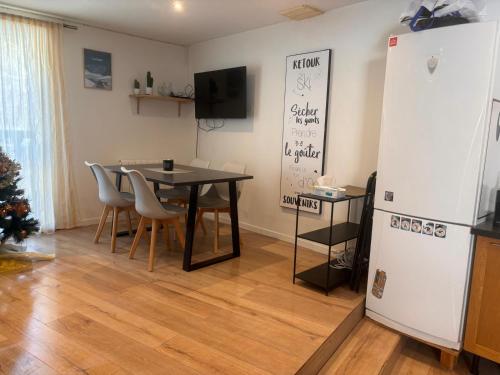 une salle à manger avec une table et un réfrigérateur dans l'établissement La maison de la montagne, à Saint-Chaffrey