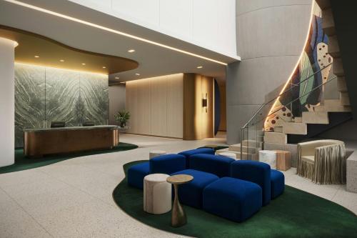 a lobby with a blue couch and a staircase at W Dallas in Dallas