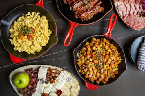 a table topped with different types of food in pans at Sheraton Phoenix Downtown in Phoenix