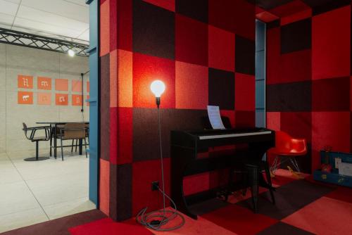 a red and black wall with a piano in a room at ibis Styles Nancy Centre Gare in Nancy