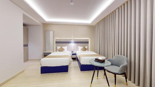 a hotel room with two beds and a table at فندق المستراح - Al Mustarah Hotel in Al Madinah