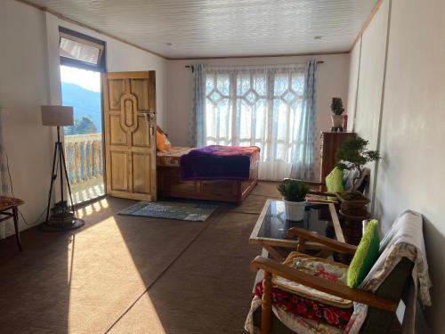 sala de estar con cama y balcón en Máple farmstay, en Darjeeling