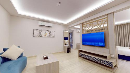 a living room with a blue couch and a flat screen tv at فندق المستراح - Al Mustarah Hotel in Al Madinah