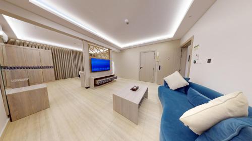 a living room with a blue couch and a tv at فندق المستراح - Al Mustarah Hotel in Al Madinah