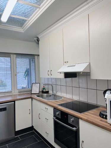 a kitchen with white cabinets and a sink at B Chez Hamdi in Knokke-Heist