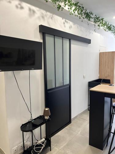 a black door in a room with a table at Agréable studio à 5min du tram in Saint-Jean-de-Védas