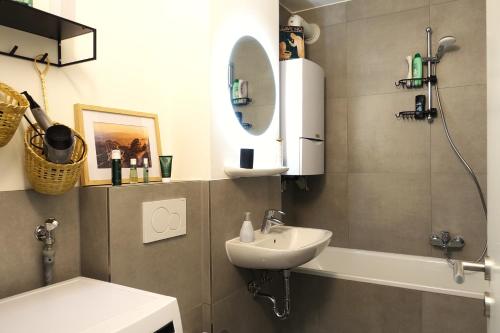 a bathroom with a sink and a mirror and a shower at Getaway Apartment - Balkon - Küche - Ruhe - Wäsche - S-Bahn - 60 qm in Duisburg