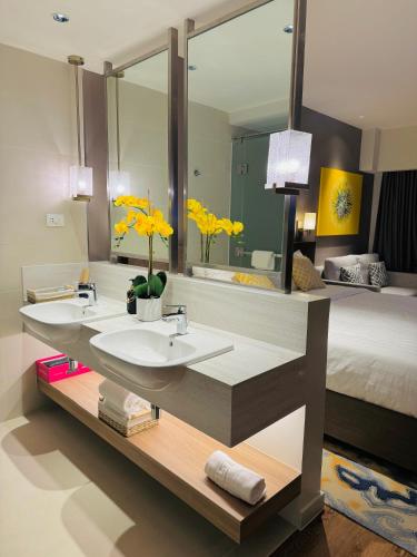 a bathroom with two sinks and a large mirror at Hotel Residences at ACQUA Tower near Rockwell Makati in Manila