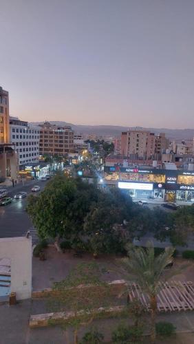 a city at night with cars and buildings at فندق الشلالات العقبهWaterfalls Hotel Aqaba in Aqaba