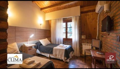 ein Schlafzimmer mit einem Bett und einem Fernseher in einem Zimmer in der Unterkunft DOMUS AUDITORIUM in Villa Carlos Paz