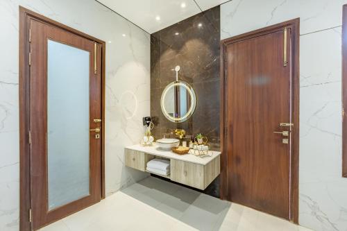 a bathroom with a sink and a mirror at ELIVAAS Prive 5 BHK Kvanya Mansion with Pvt Pool & Home Theater in Debāri