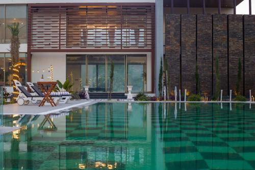 a swimming pool in front of a house at ELIVAAS Prive 5 BHK Kvanya Mansion with Pvt Pool & Home Theater in Debāri