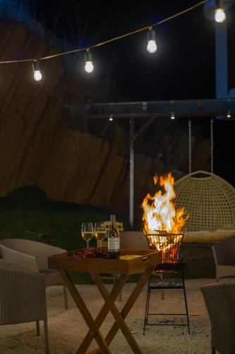 a table with wine glasses and a fire at ELIVAAS Prive 5 BHK Kvanya Mansion with Pvt Pool & Home Theater in Debāri
