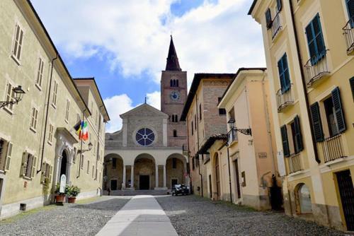 a building with a church with a steeple in a street at Alloggio nella Villa dell'Edera in Acqui Terme