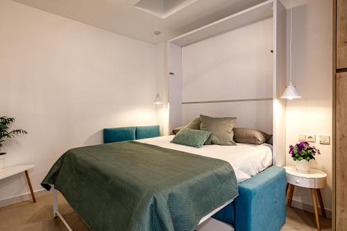 a bedroom with a bed with a blue chair at La Capilla del Cabo Apt 2 in Cabo de Palos