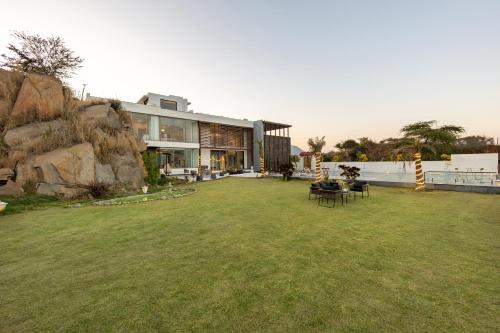 a house with a large yard in front of a building at ELIVAAS Prive 5 BHK Kvanya Mansion with Pvt Pool & Home Theater in Debāri