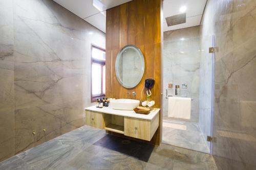 a bathroom with a sink and a mirror at ELIVAAS Prive 5 BHK Kvanya Mansion with Pvt Pool & Home Theater in Debāri
