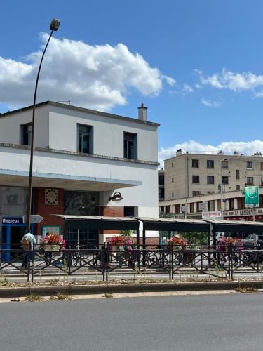 un bâtiment avec des tables devant un bâtiment dans l'établissement Cosy 2 pièces à 15 min de Paris, à Bagneux