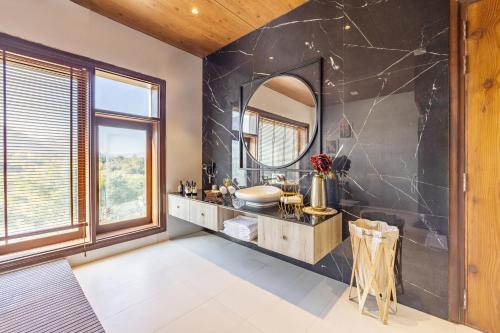 a bathroom with a sink and a mirror at ELIVAAS Prive 5 BHK Kvanya Mansion with Pvt Pool & Home Theater in Debāri