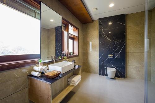 a bathroom with a sink and a mirror at ELIVAAS Prive 5 BHK Kvanya Mansion with Pvt Pool & Home Theater in Debāri