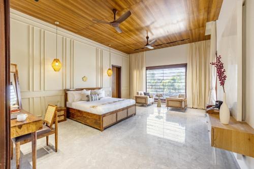 a bedroom with a bed and a living room at ELIVAAS Prive 5 BHK Kvanya Mansion with Pvt Pool & Home Theater in Debāri