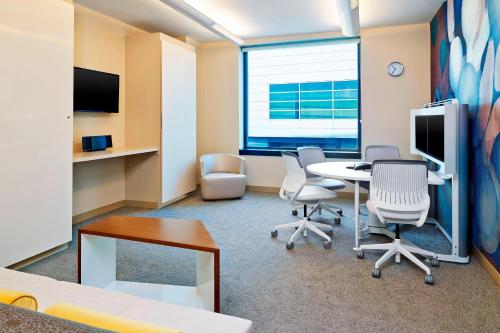 a room with a table and chairs and a desk at The Westin Detroit Metropolitan Airport in Romulus