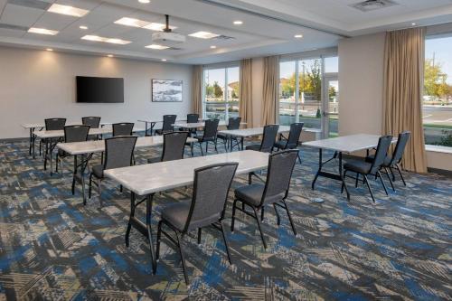 a conference room with tables and chairs and a screen at SpringHill Suites by Marriott Indianapolis Keystone in Indianapolis