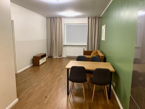 a room with a table and chairs and a green wall at Maleva Stay at - two room apartment in Tallinn