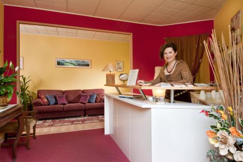 a woman sitting at a counter in a room at Villa Ferrari, Le Betulle in San Maurizio dʼOpaglio