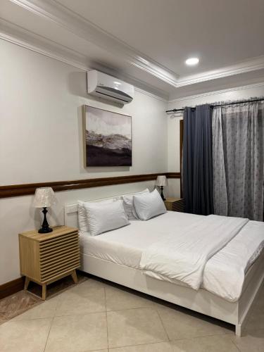 ein Schlafzimmer mit einem großen weißen Bett und einem Fenster in der Unterkunft Villa De Ciudad in Lapu Lapu City