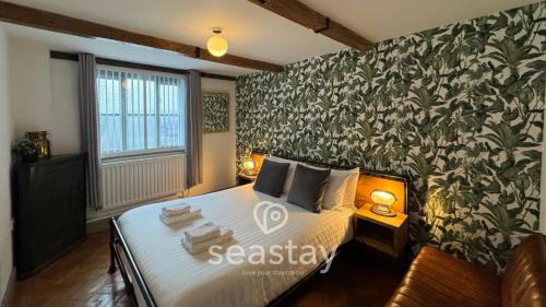 a bedroom with a bed with a floral wallpaper at Old Boathouse 3 Bed 2 Bath Nr Beach Inc Parking in Broadstairs
