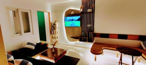 a living room with a couch and a television at Bohemian Stay in Dehradun