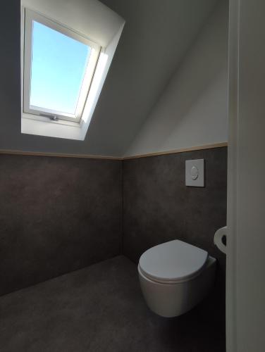 a bathroom with a white toilet and a window at Apartment 58- Ruhr Nah in Essen