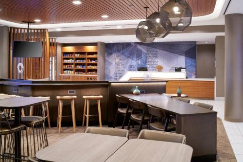 a restaurant with tables and chairs and a bar at SpringHill Suites by Marriott Wixom Novi in Wixom