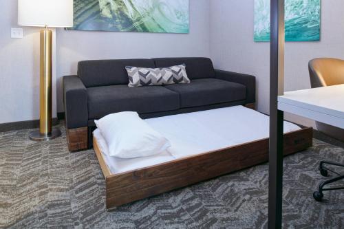 a couch and a bed in a room at SpringHill Suites by Marriott Wixom Novi in Wixom
