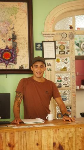 a man sitting at a counter with a laptop at POA Eco Hostel in Porto Alegre