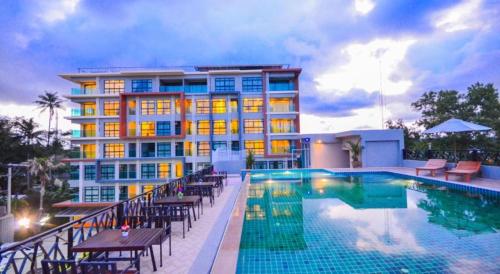 a hotel with a swimming pool and a building at Golden Manora Hotel Bangtao Beach Phuket in Bang Tao Beach