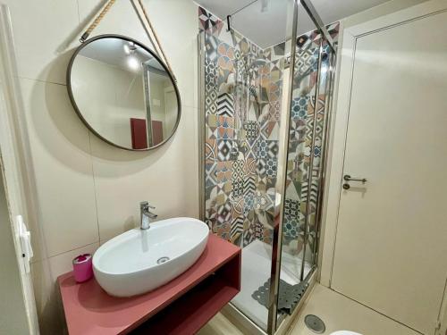 ein Badezimmer mit Waschbecken und Dusche mit Spiegel in der Unterkunft iMinerva Garden Panoramic Suite in Salerno