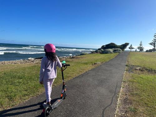a young girl riding a scooter on a path at Devonport Breeze Escape in Devonport