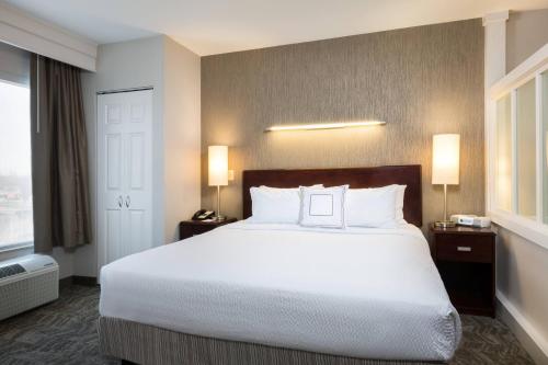 a hotel room with a large bed with white pillows at SpringHill Suites Indianapolis Fishers in Indianapolis