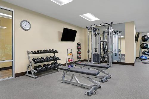 a fitness room with several machines and a clock at TownePlace Suites By Marriott Lima in Lima